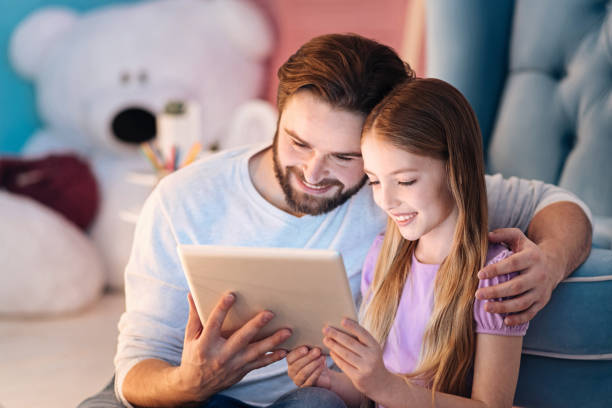 istock Happy man sitting on blue sofa with daughter 666540260