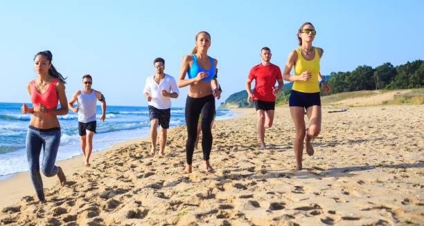 istock Group of friends running on beach 666545350