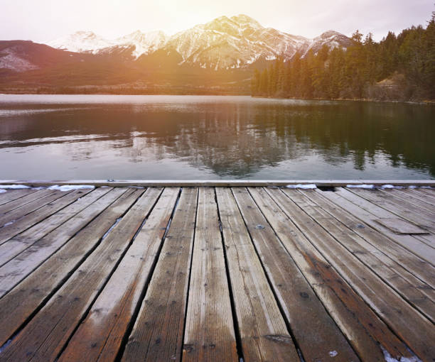 istock Wood table top on lake and mountain with snow background 666545744