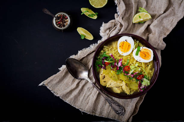 istock Noodle soup with chicken, celery and egg in a bowl on a black background. Flat lay. Top view. 666553202