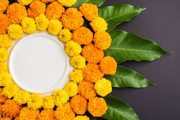 istock flower rangoli made using marigold or zendu flowers and mango leaves over black background with copy space in the middle, selective focus 666553462