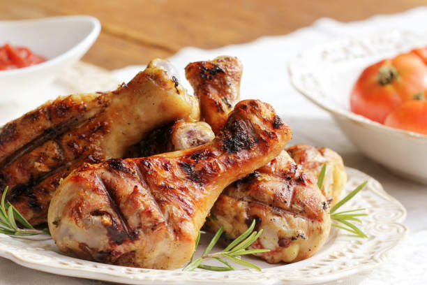 istock Grilled chicken legs with rosemary on table 666573010