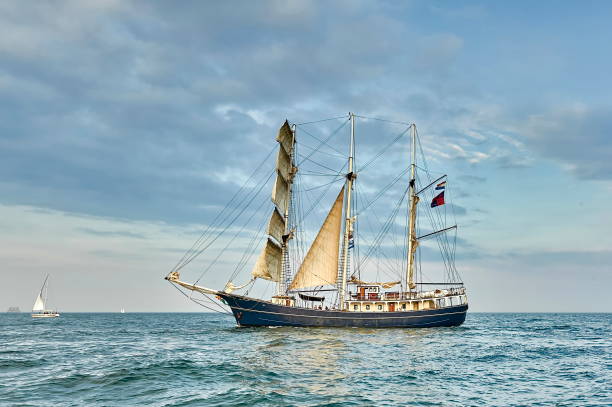 istock Tall Ship under sail with the shore in the background 666573314