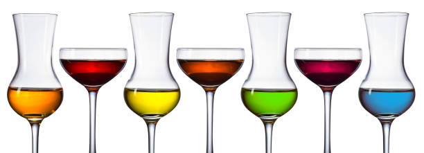 Glasses of different alcoholic drinks isolated on a white background . Blue , green , yellow , orange and different shades of red .