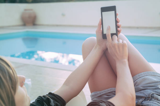 istock Girl using cellphone near the swimming pool. 666586646