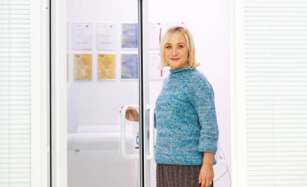 istock happy elderly woman enters office door 666590432
