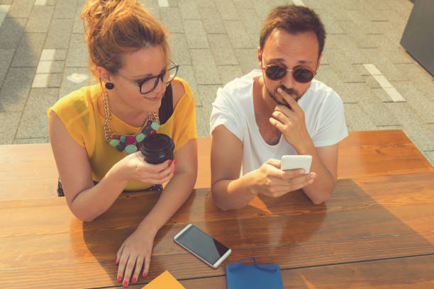 istock Group of people using cellphone outdoors. 666593308