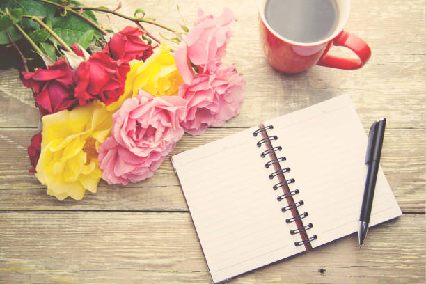 istock roses,cup of coffee and notebook on table 666593576