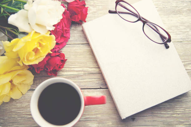 istock roses,coffee and book on wooden  table 666593698