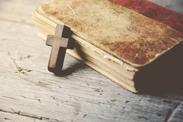 istock Crosses and book on a wooden table 666595822