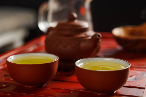 istock Two bowls with fresh oolong tea on tea desk. 666597230
