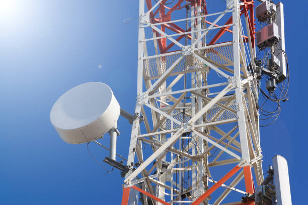 istock Mobile phone communication antenna tower with satellite dish on blue sky background 666599978