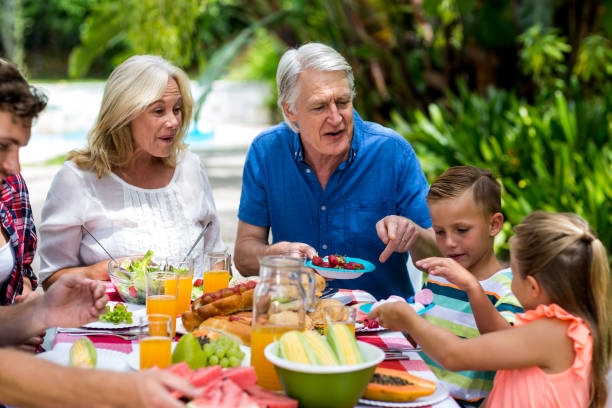 istock Granparents having breakfast with family at yard 666607236