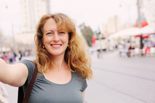 Portrait of smiling 40 years old woman outdoors Portrait of smiling 40 years old woman outdoors hair care women mature adult human skin stock pictures, royalty-free photos & images