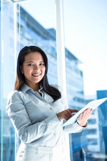 istock Smiling businesswoman using tablet and looking at camera 666608506