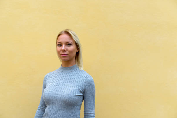 istock Young beautiful woman against beige-colored wall 666608804