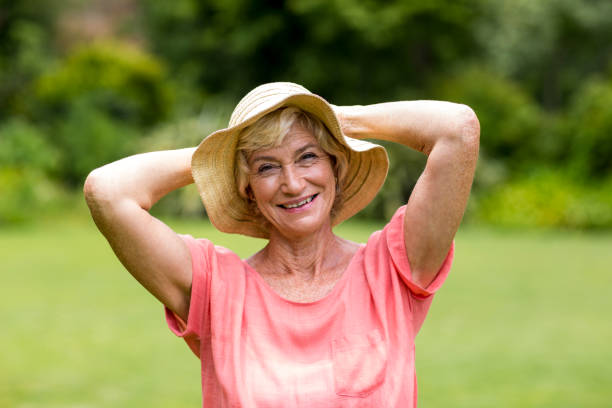 istock Senior woman wearing hat standing in yard 666617390