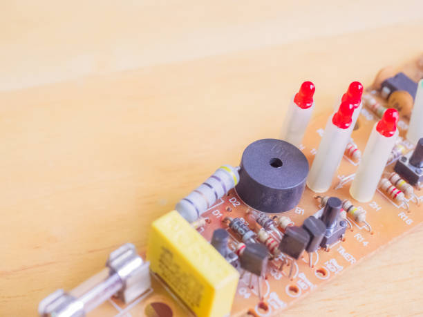 istock four red LED and black speaker and black transistor on print circuit board with texture wood background and foreground soft focus 666620180