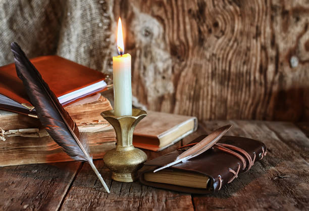 istock feather and book novel close to the a candle 666621388