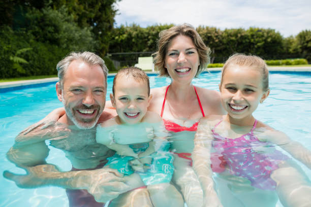 istock Happy parents and kids in pool 666621498