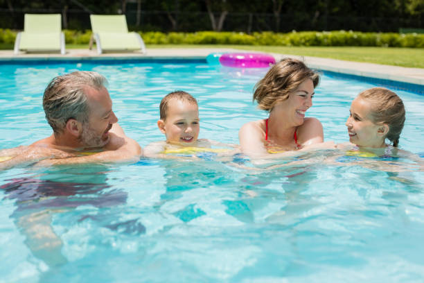 istock Parents and kids having fun in poolside 666621782