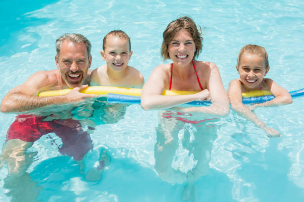 istock Happy parents and kids in pool 666621902
