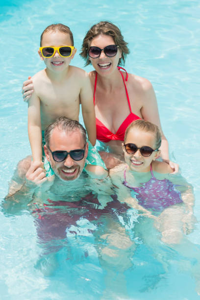 istock Happy parents and kids in pool 666624818