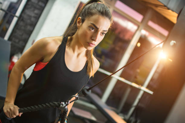 istock Young sporty girl working out on pull-down machine in gym. 666627926