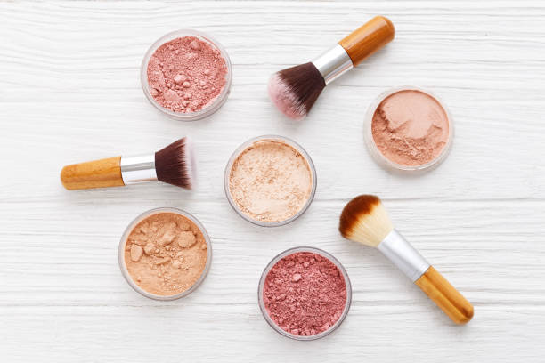 istock Makeup powder with brushes on wood background 666644158