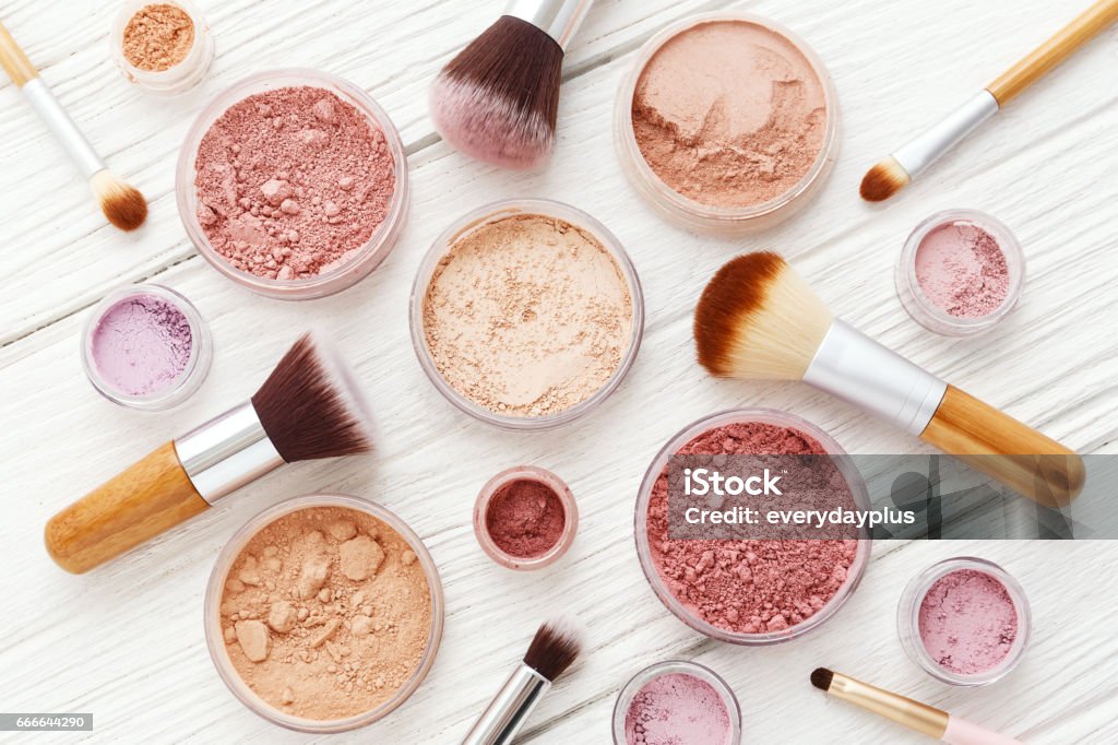 Makeup powder and brushes on white wood flat lay Makeup powder products with foundation blush eye shadow and brush on white wood background flat lay Make-Up Stock Photo