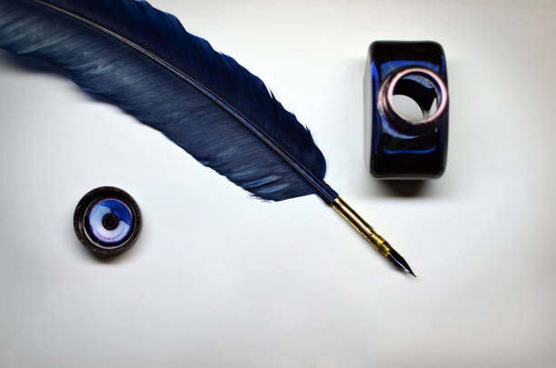 Ink and quill Opened bottle of blue ink and quill over white paper ink well stock pictures, royalty-free photos & images