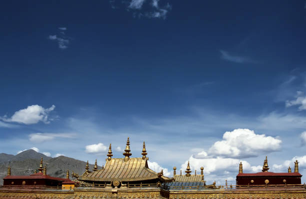 cielo tibetano sobre los tejados dorados y spiers del templo de jokhang. - tibetan buddhism wind tibet horizontal fotografías e imágenes de stock