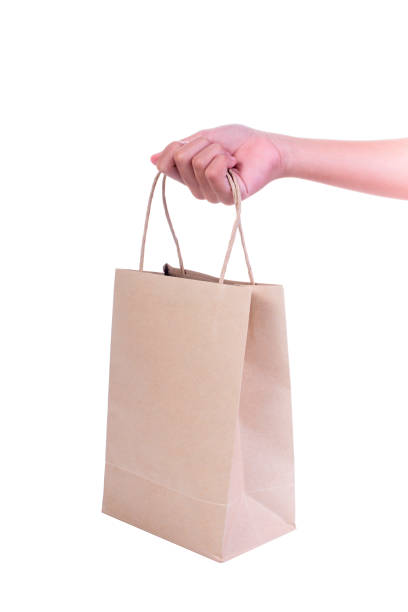istock Female hand holding paper bag isolated on white background 666654526