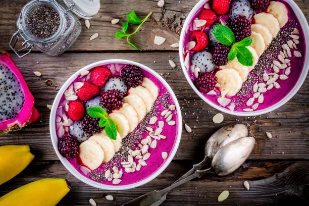 Blueberry smoothie bowl with banana, raspberry, pitaya, blackberry, almonds, sunflower and chia seeds Healthy breakfast bowl: blueberry smoothie with banana, raspberry, pitaya, blackberry, almonds, sunflower and chia seeds dragon fruit flower stock pictures, royalty-free photos & images