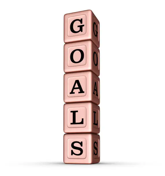 Photo of GOALS word sign. Vertical Stack of Rose Gold Toy Blocks.