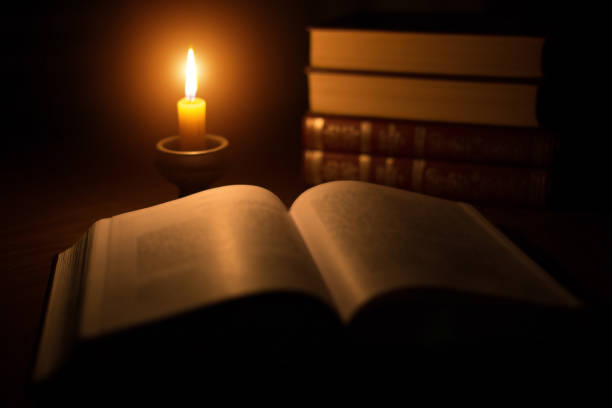 istock The burning candle against books 666678832