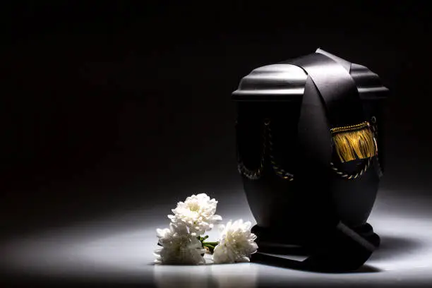 funeral urn, with tape and flower decorated, for sympathy, card