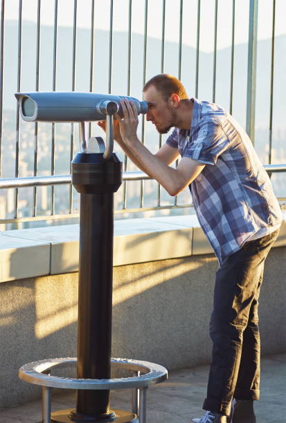 istock Cheerful young tourist using telescope tower observation deck 666681854