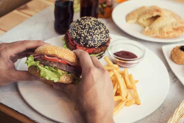 istock Man eating burgers 666686170