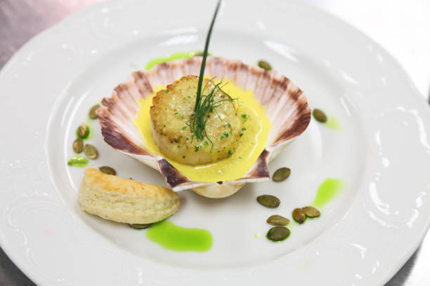 istock Scallop in a shell with grits, pumpkin seeds and saffron sauce. 666710328