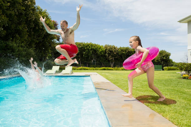 istock Happy father and daughter jumping in swimming pool 666738270