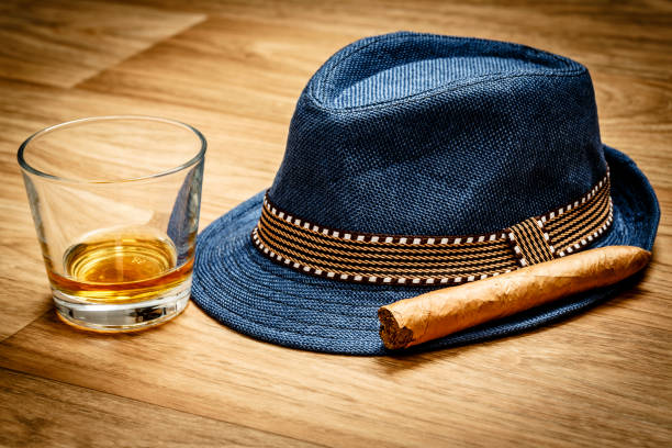 blue hat with cigar and expensive drink of whisky or rum on wooden floor - cigar whisky bar cognac imagens e fotografias de stock