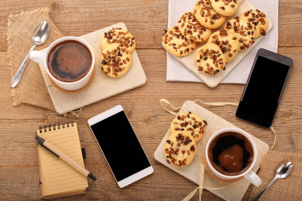 Cup of coffee and heart shape cookie on wood