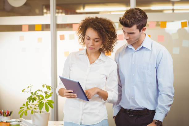istock Business woman using digital tablet while male colleague 666756512