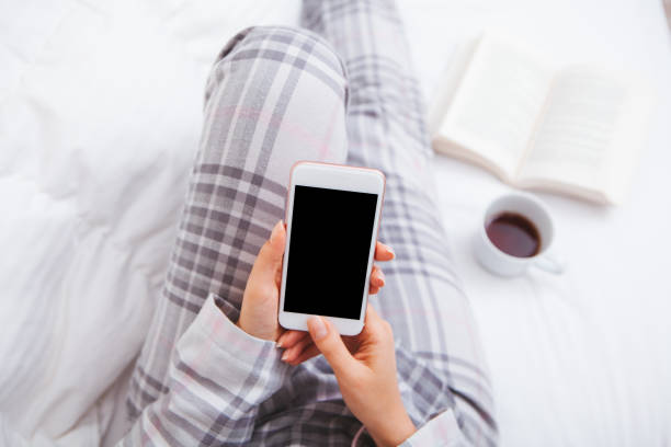 mujer con smartphone en cama - working bed smart phone bedroom fotografías e imágenes de stock