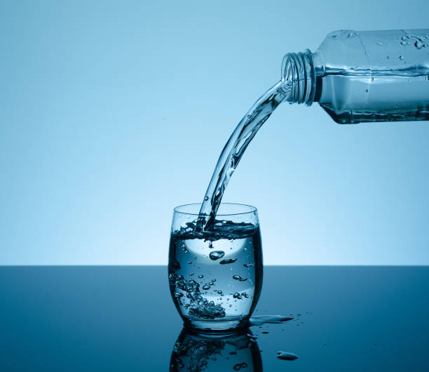 istock Bottle with creative splashing water in the glass 666766700