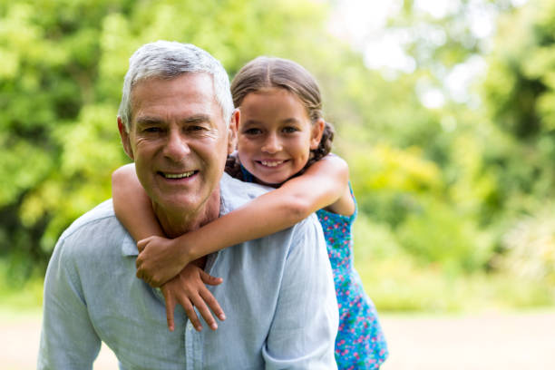 istock Grandfather carrying grandaughter in yard 666766940