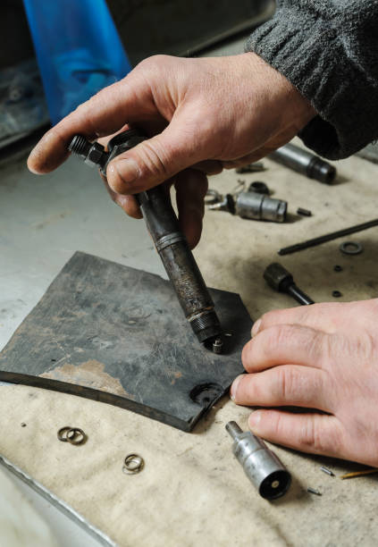 istock Mechanics repairing a diesel injector. 666769382