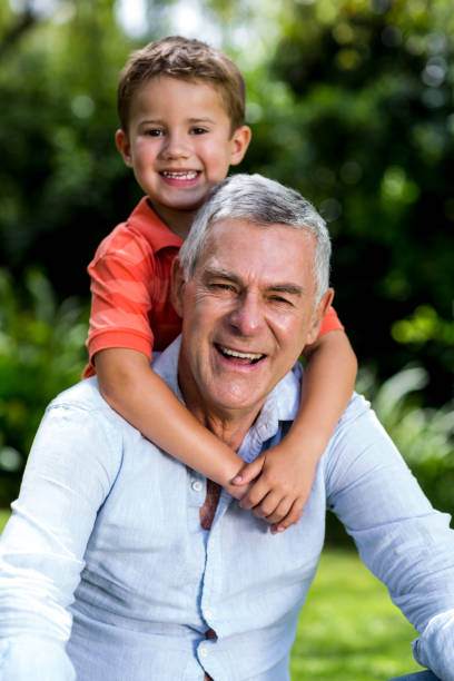 istock Grandfather with grandson sitting in yard 666769456
