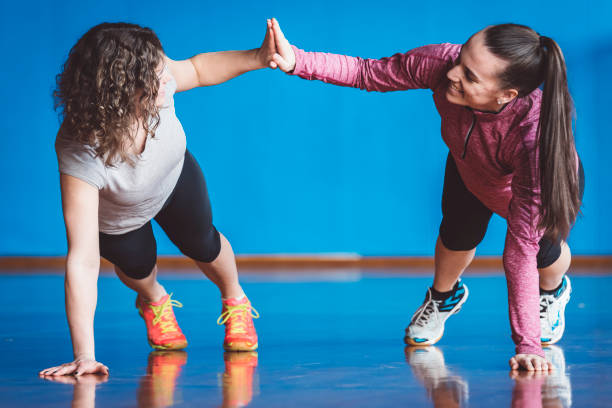 istock Smiling athletic friends doing push-ups in gym 666769554